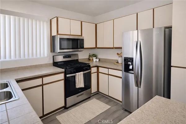 a kitchen with stainless steel appliances granite countertop a refrigerator stove and microwave