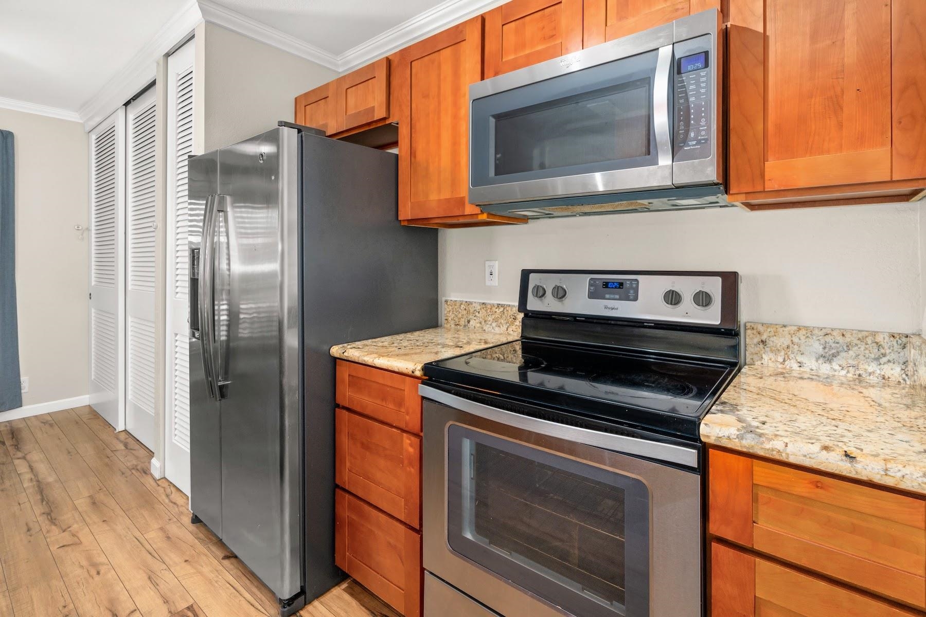 480 Kenolio Road, Unit 12201 Kihei, HI 96753 - Photo 4 of 25 a kitchen with granite countertop cabinets stainless steel appliances and a counter space