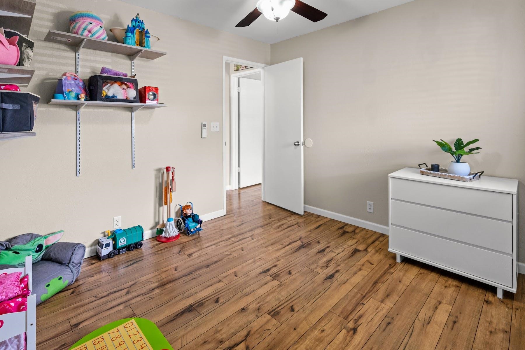 480 Kenolio Road, Unit 12201 Kihei, HI 96753 - Photo 8 of 25 a room with a bed wooden floor and ceiling fan