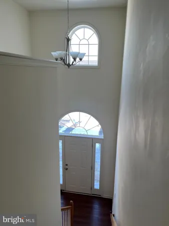 an empty room with wooden floor cabinet and mirror