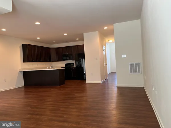 a view of kitchen with a refrigerator and a microwave