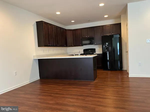 a kitchen with stainless steel appliances wooden cabinets and wooden floor