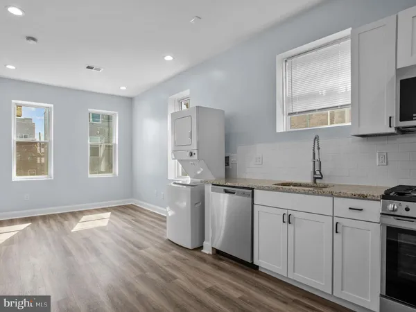 a kitchen with stainless steel appliances a stove microwave and refrigerator