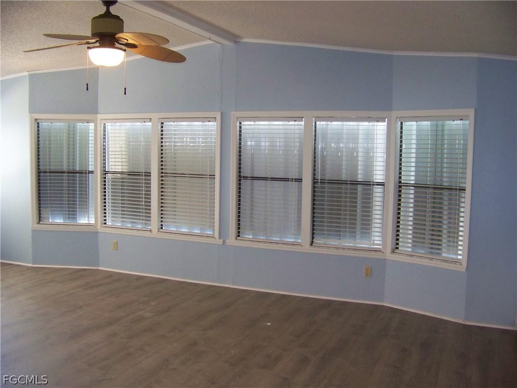 15550 Burnt Store Road, Unit 101 Punta Gorda, FL 33955 - Photo 13 of 50 an empty room with chandelier fan and windows