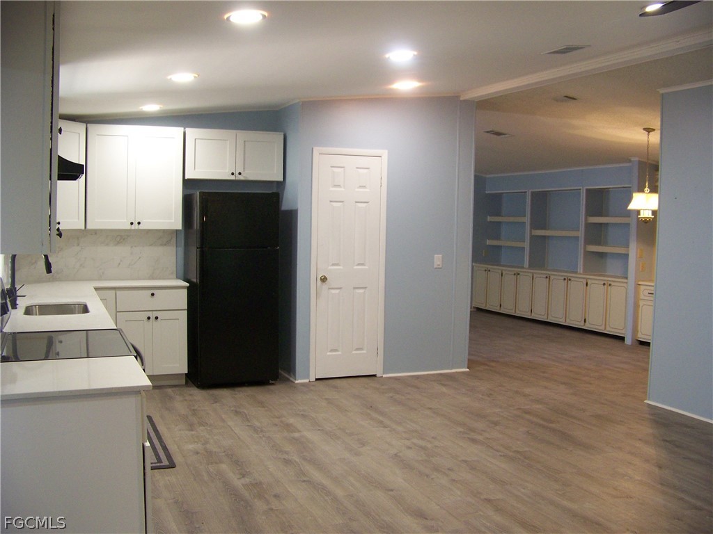 15550 Burnt Store Road, Unit 101 Punta Gorda, FL 33955 - Photo 23 of 50 a view of a kitchen with refrigerator and wooden cabinets