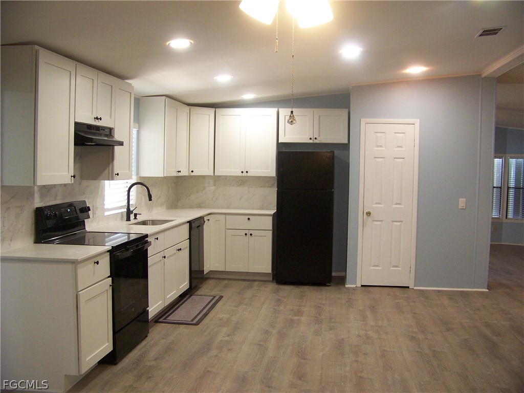 15550 Burnt Store Road, Unit 101 Punta Gorda, FL 33955 - Photo 24 of 50 a kitchen with a sink a refrigerator and cabinets