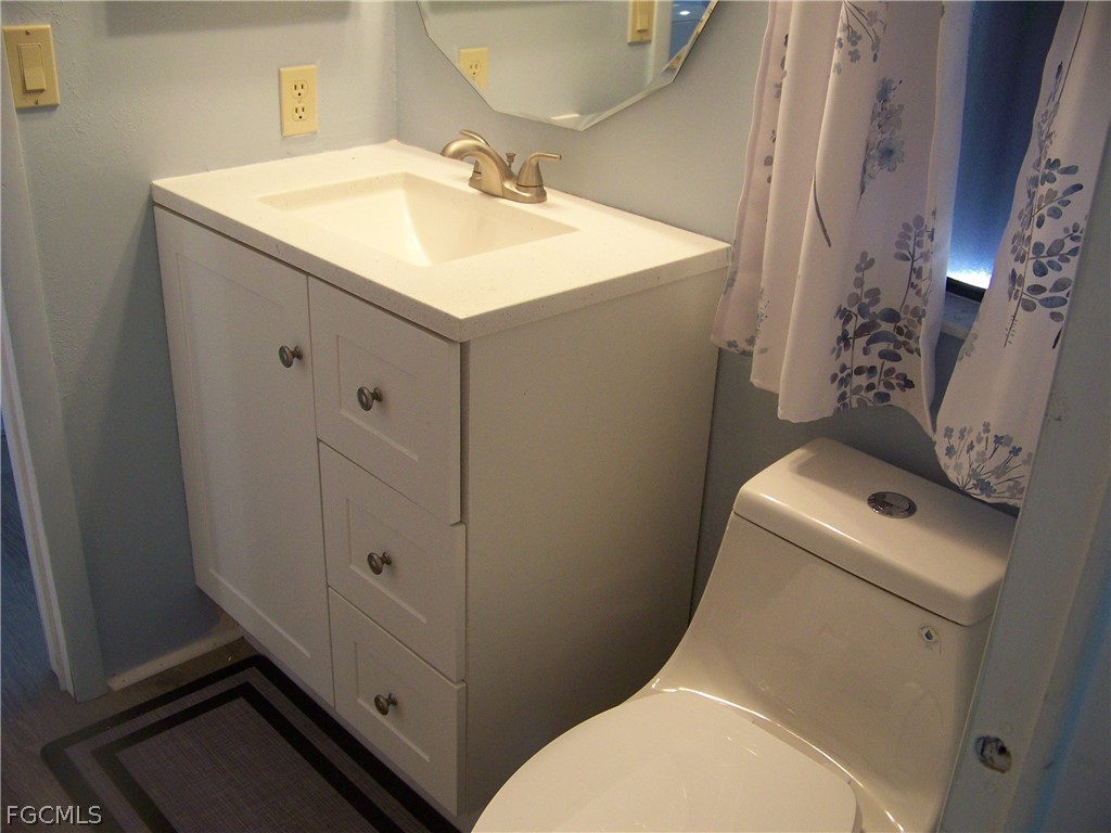 15550 Burnt Store Road, Unit 101 Punta Gorda, FL 33955 - Photo 29 of 50 a bathroom with a sink toilet and mirror