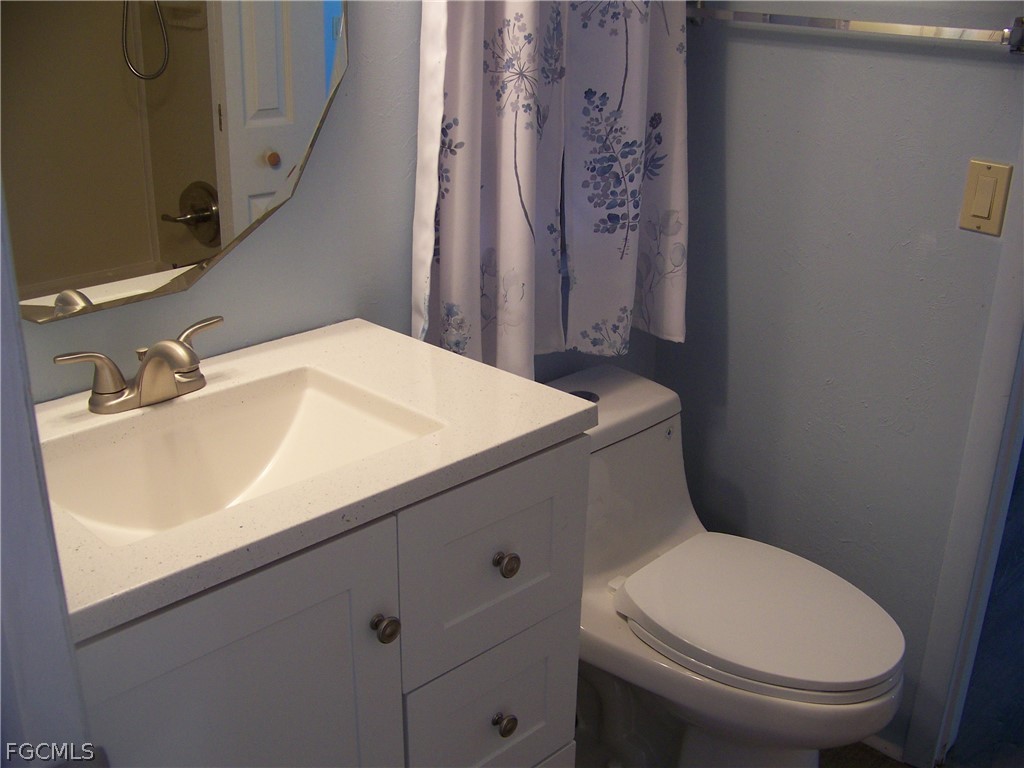15550 Burnt Store Road, Unit 101 Punta Gorda, FL 33955 - Photo 31 of 50 a white toilet sitting next to a bathroom sink
