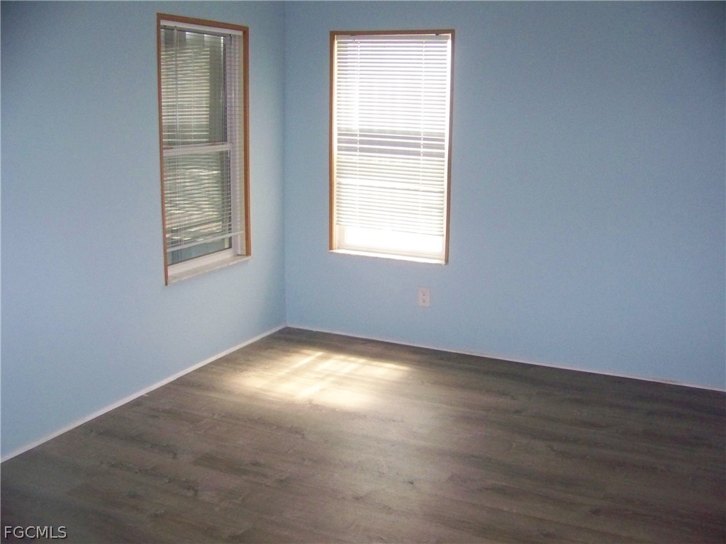 15550 Burnt Store Road, Unit 101 Punta Gorda, FL 33955 - Photo 33 of 50 an empty room with wooden floor and windows
