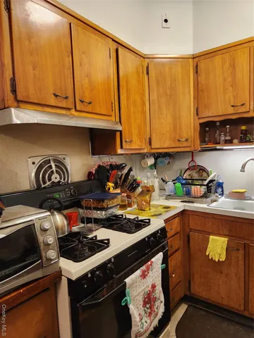 a kitchen with a sink a stove and cabinets