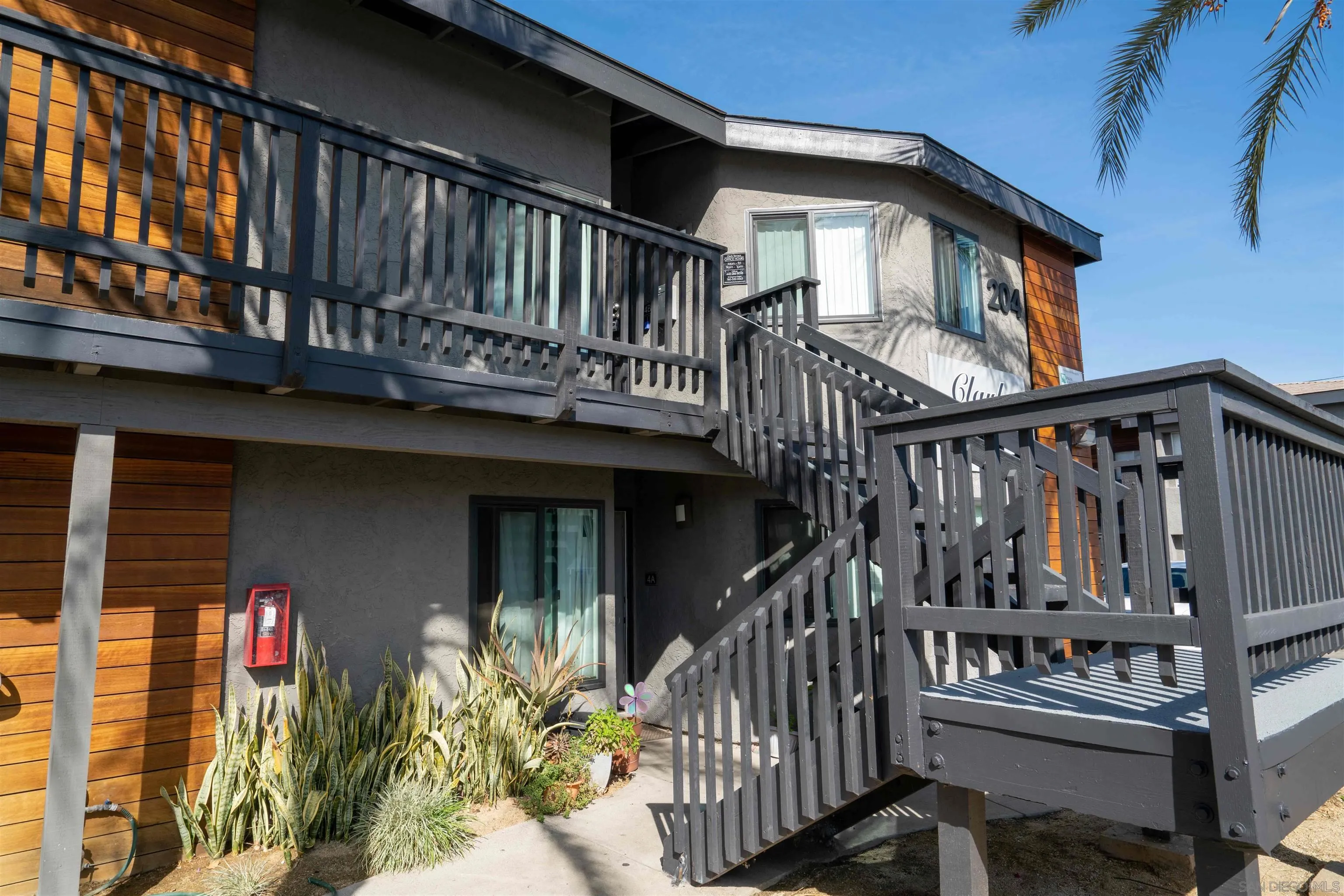 204 Clark Street Escondido, CA 92025 - Photo 2 of 6 a view of wooden house with large windows and flower plants