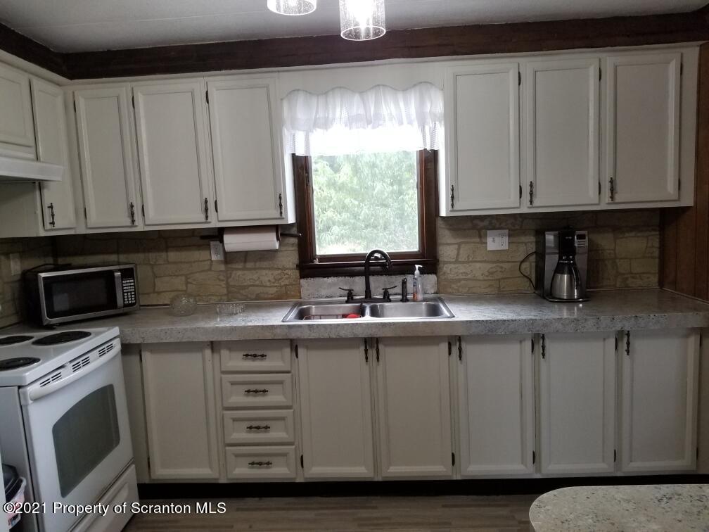 337 Main Street Forest City, PA 18421 - Photo 6 of 6 a kitchen with stainless steel appliances granite countertop a sink a microwave a window and cabinets