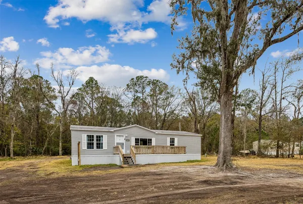 a front view of a house with a yard and trees