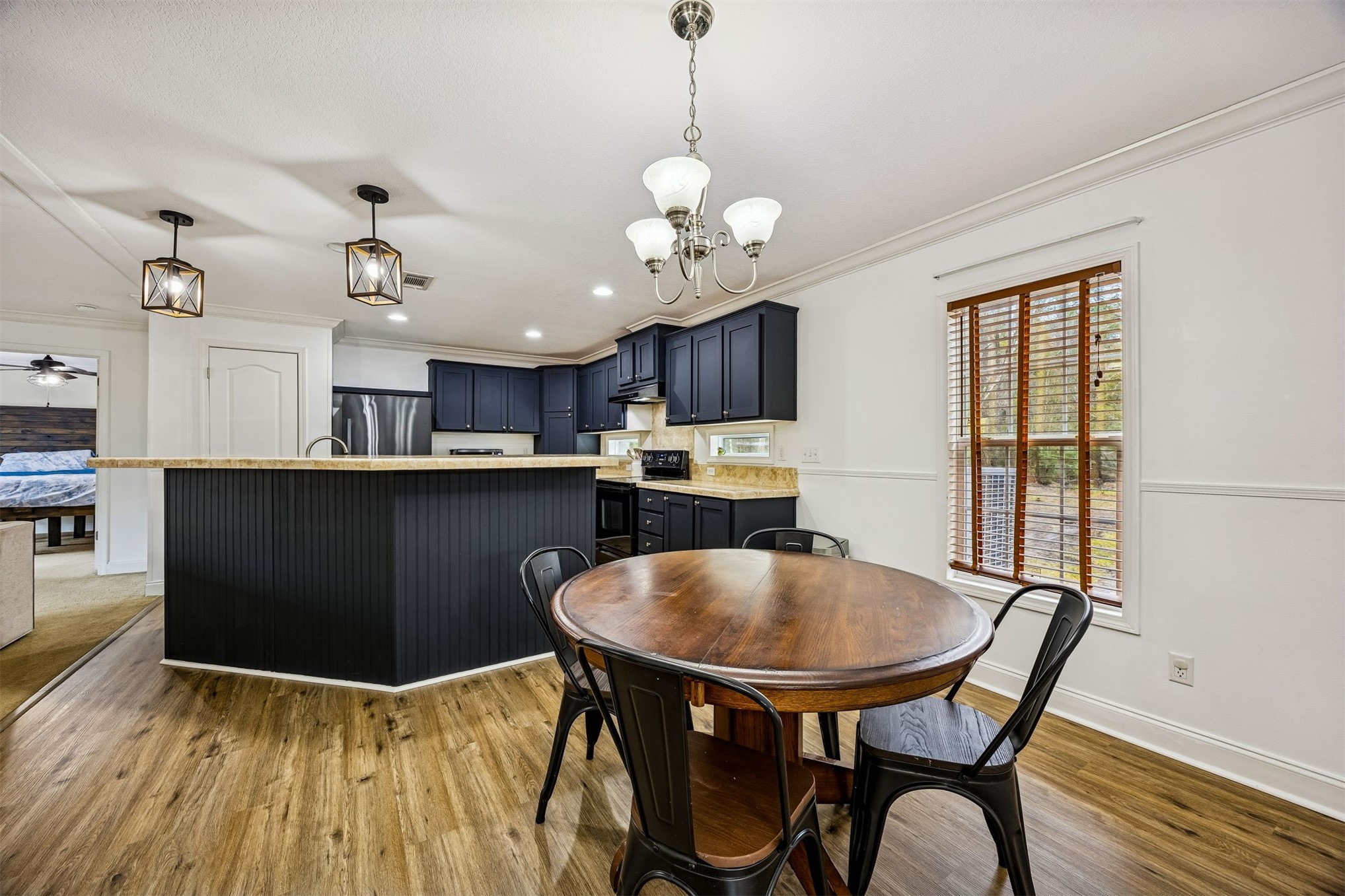 54124 Catherine Avenue Callahan, FL 32011 - Photo 4 of 29 a kitchen with kitchen island a dining table chairs stainless steel appliances and cabinets
