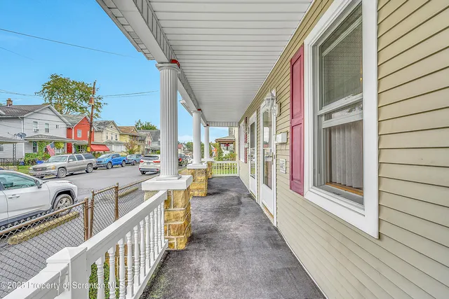 a view of a balcony and car parked on the street
