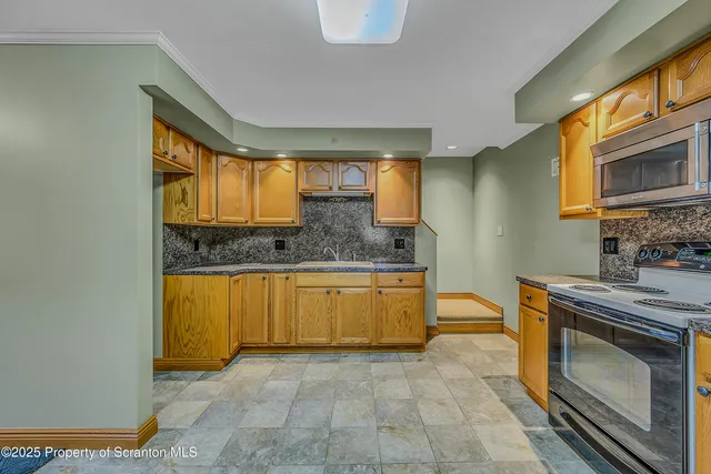 a kitchen with stainless steel appliances granite countertop a stove a sink and a microwave