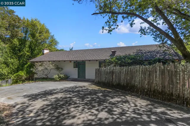 a view of a house with a wooden fence