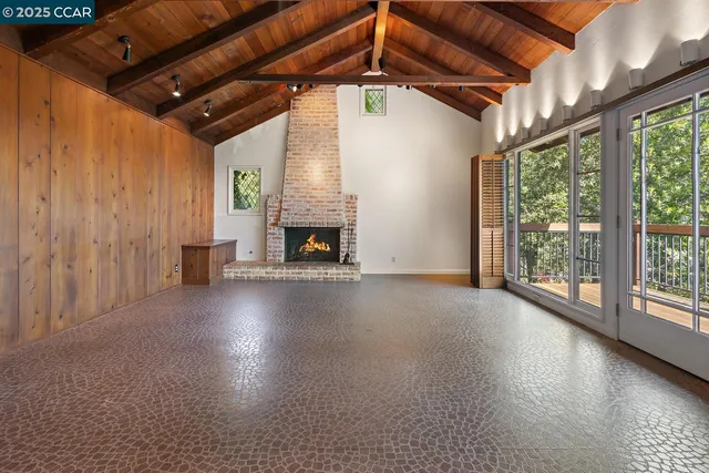 a view of empty room with fireplace and wooden floor