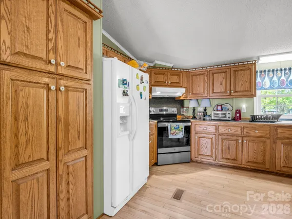 a kitchen with stainless steel appliances granite countertop a refrigerator and cabinets