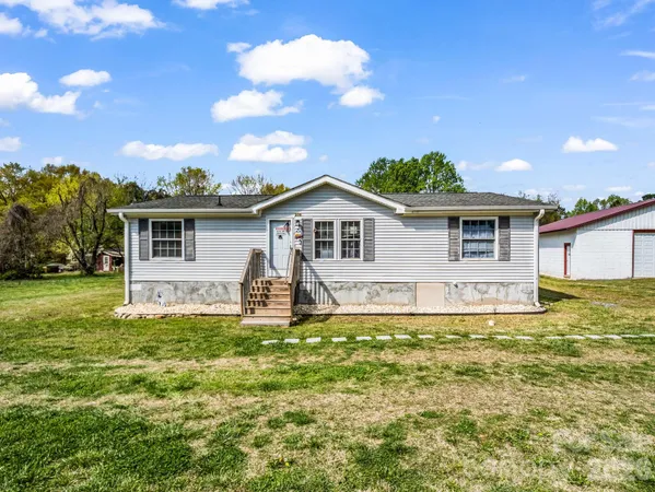 a view of a house with a yard and sitting area