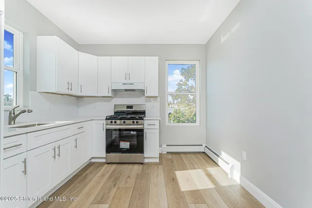 a kitchen with white cabinets and appliances