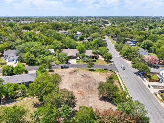 an aerial view of residential houses with outdoor space and street view