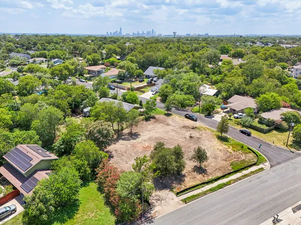an aerial view of residential houses with outdoor space and trees