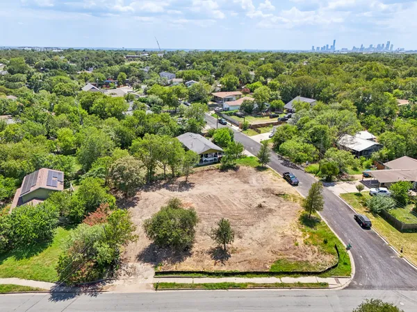 an aerial view of a houses with a yard and lake view