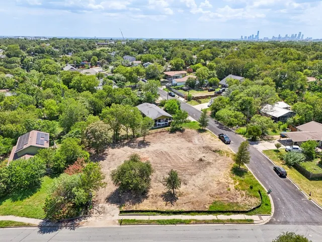 an aerial view of a houses with a yard and lake view