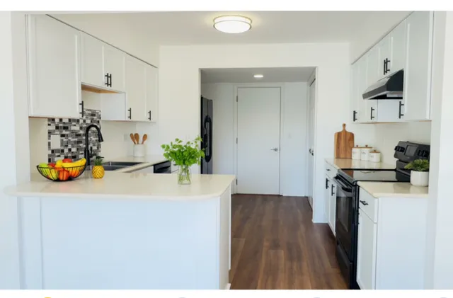 a kitchen with stainless steel appliances a sink a refrigerator and a counter top space