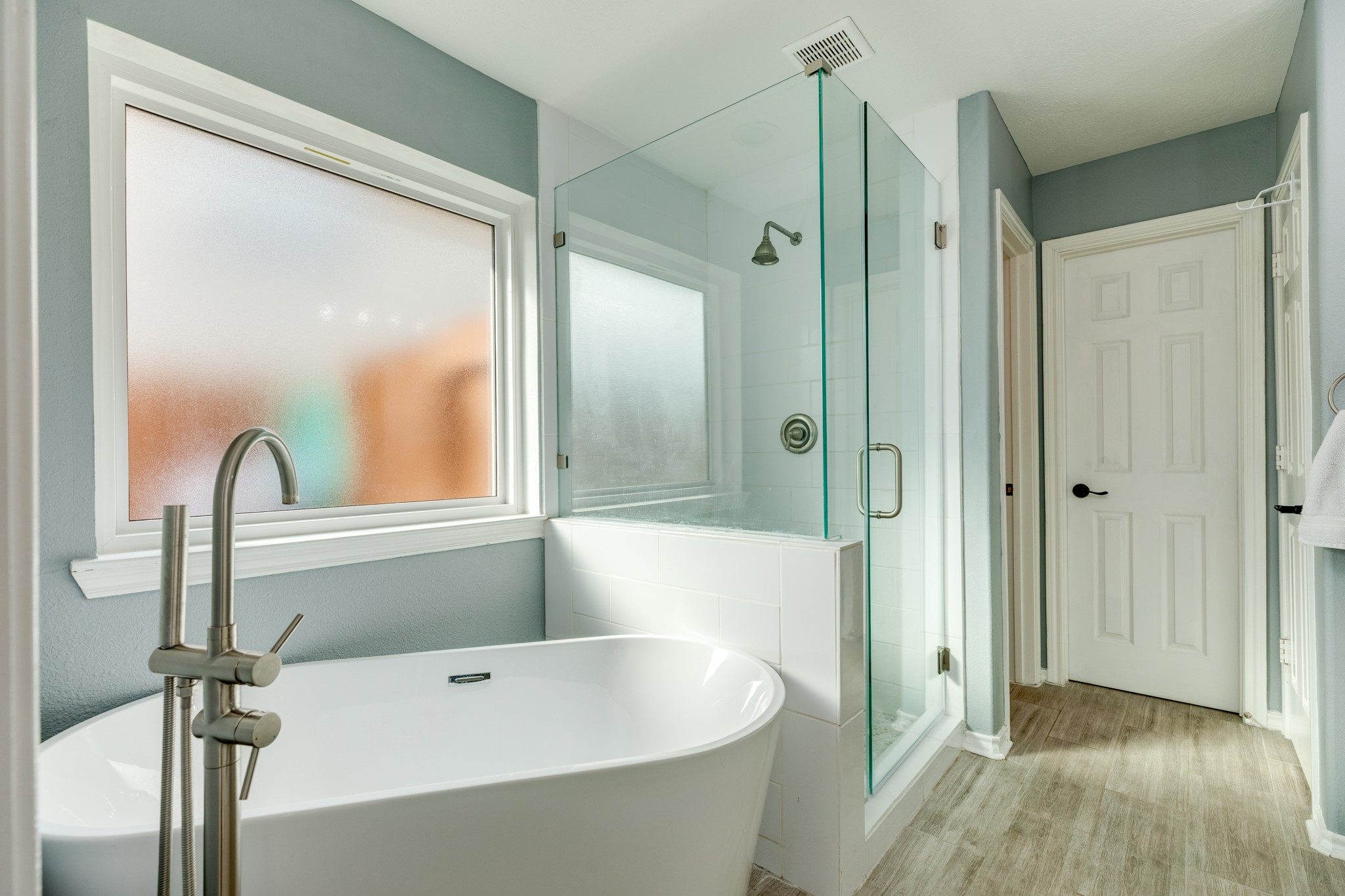 4113 Merlet Drive Pearland, TX 77584 - Photo 20 of 36 Modern updated primary bathroom with soaking tub and walk-in shower. The space features contemporary design elements, offering both relaxation and functionality.