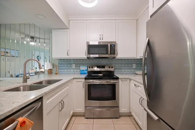 a kitchen with stainless steel appliances granite countertop a sink stove and microwave
