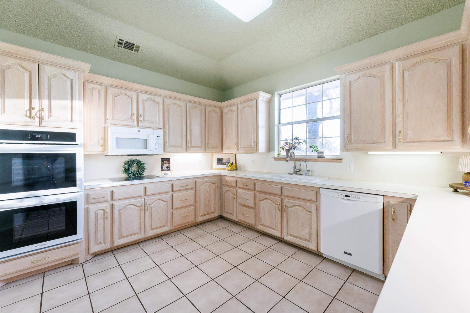 206 Collins Avenue Sundown, TX 79372 - Photo 20 of 82 a kitchen with white cabinets appliances and a window