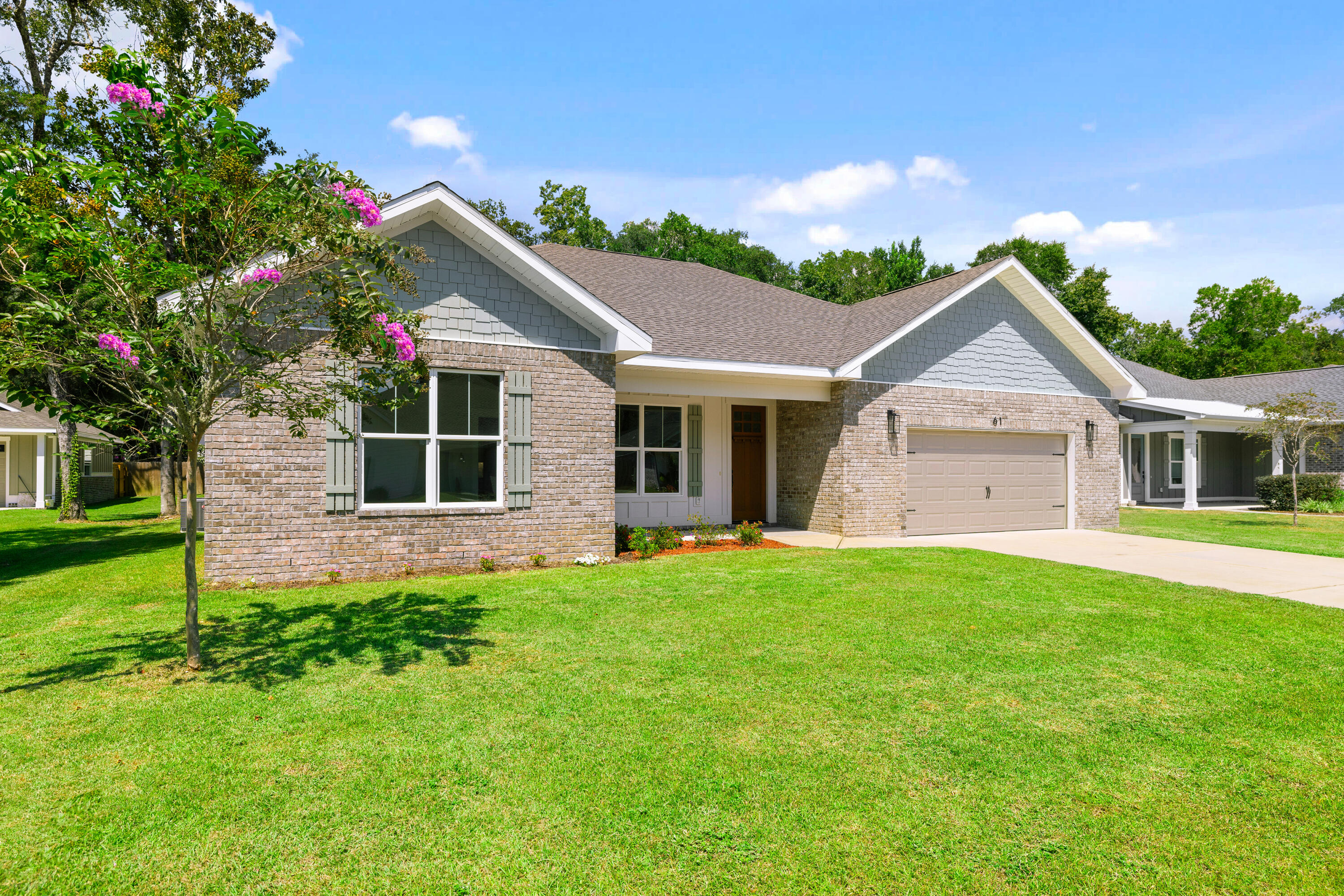 61 Spruce Street Freeport, FL 32439 - Photo 1 of 35 a front view of a house with a garden and yard
