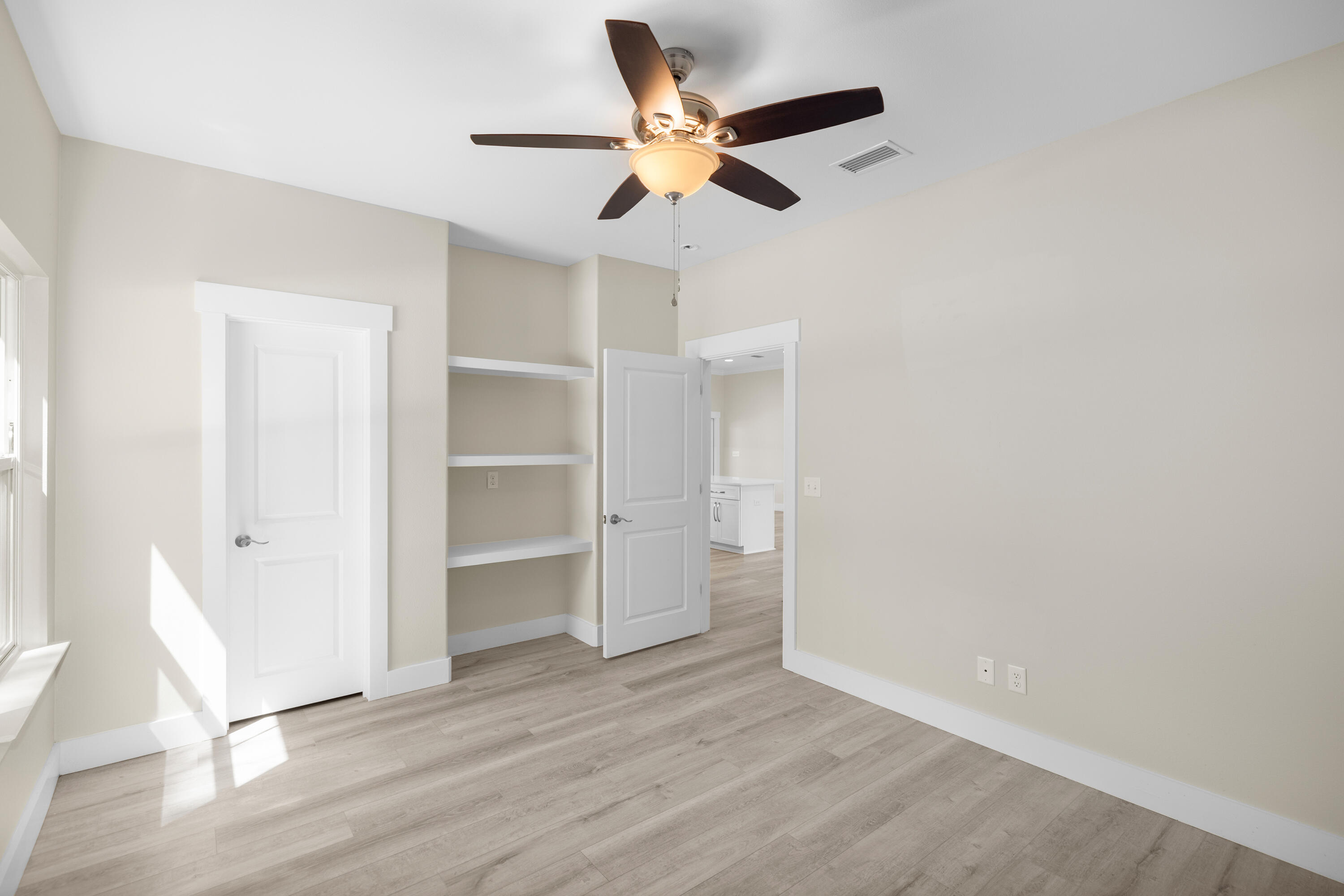 61 Spruce Street Freeport, FL 32439 - Photo 17 of 35 a view of an empty room with a window and wooden floor