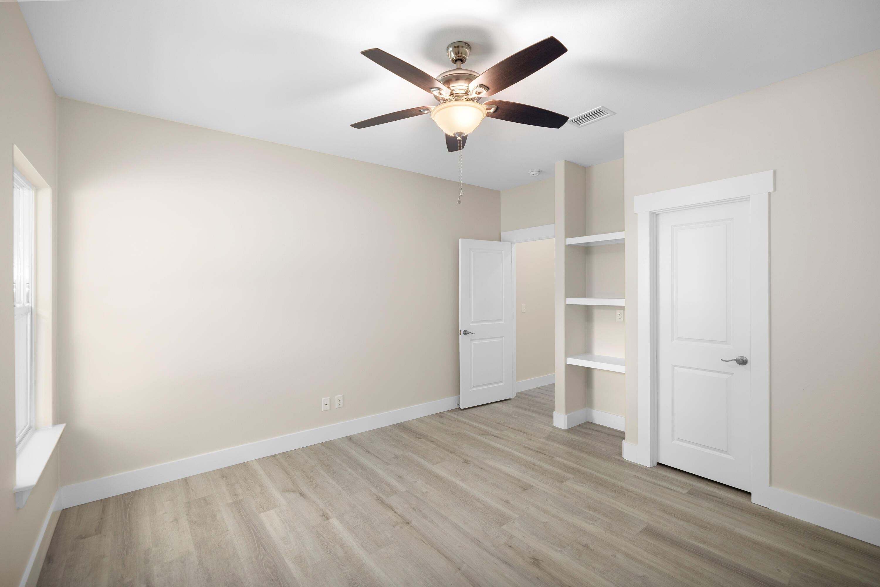 61 Spruce Street Freeport, FL 32439 - Photo 18 of 35 an empty room with wooden floor and ceiling fan