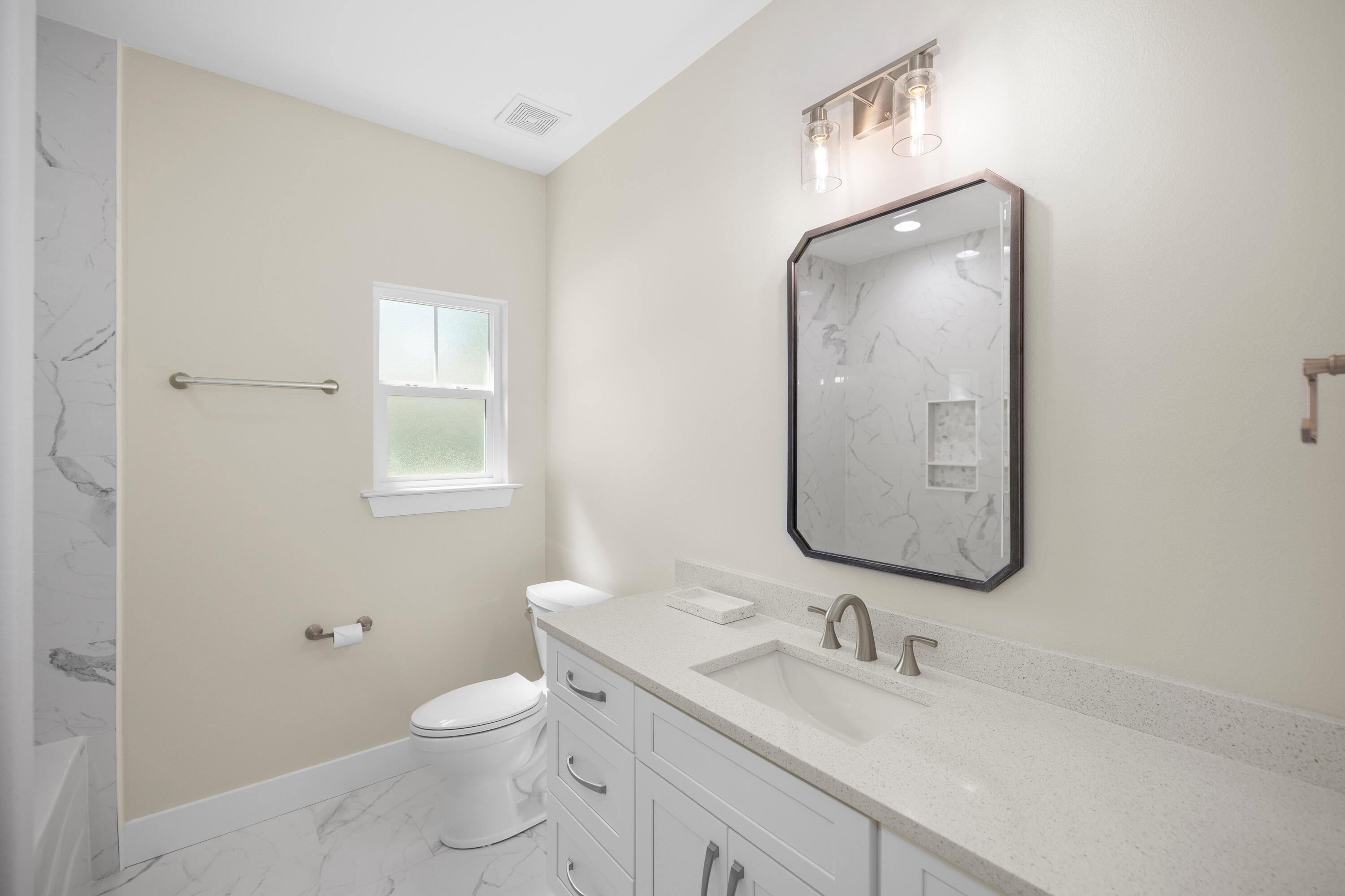 61 Spruce Street Freeport, FL 32439 - Photo 19 of 35 a bathroom with a toilet a sink and mirror