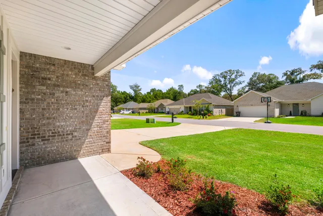a view of a house with backyard and tree