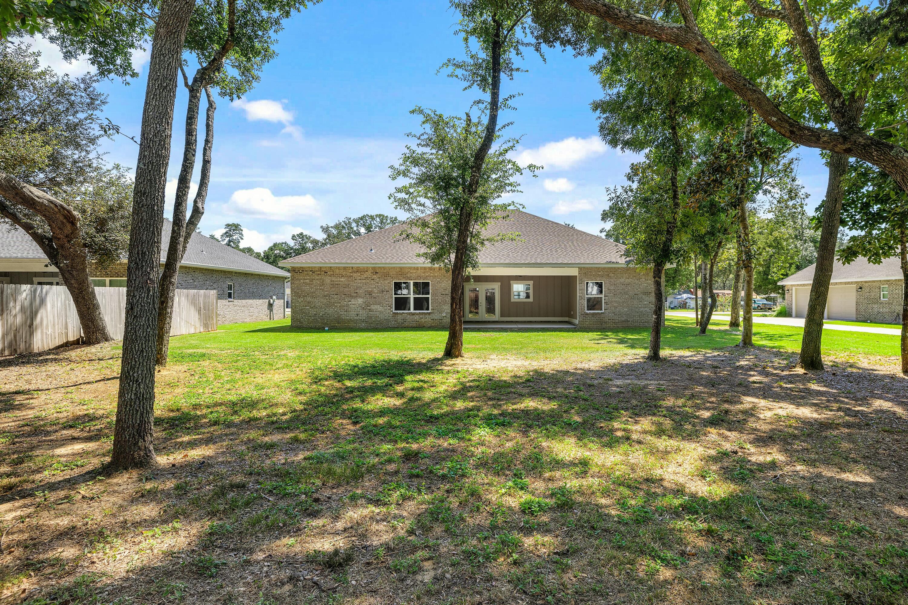 61 Spruce Street Freeport, FL 32439 - Photo 30 of 35 a view of a house with backyard and tree