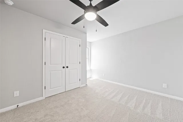 an empty room with chandelier fan