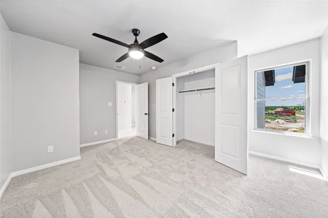 a view of a livingroom with a ceiling fan and window