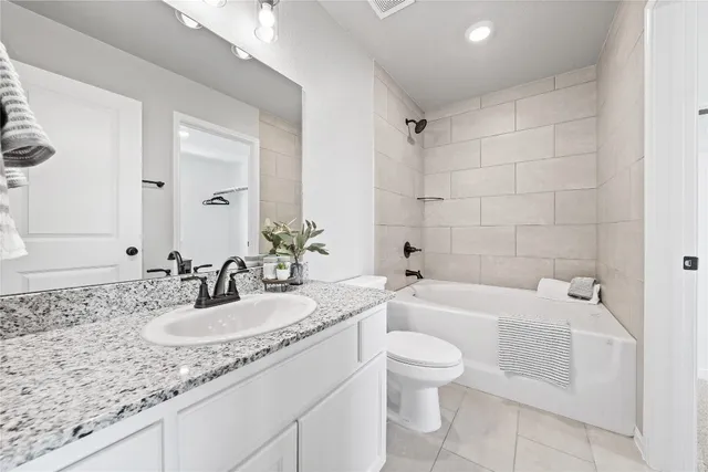 a bathroom with a granite countertop sink a toilet and bathtub