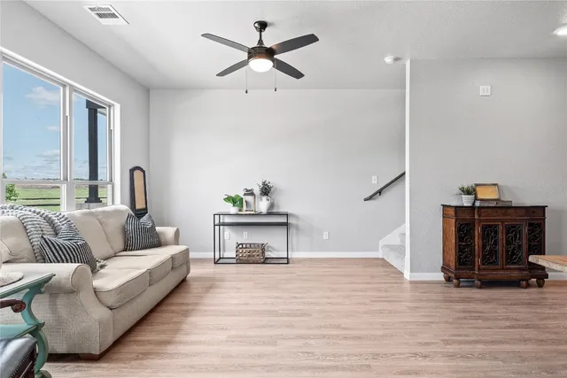 a living room with furniture and a wooden floor