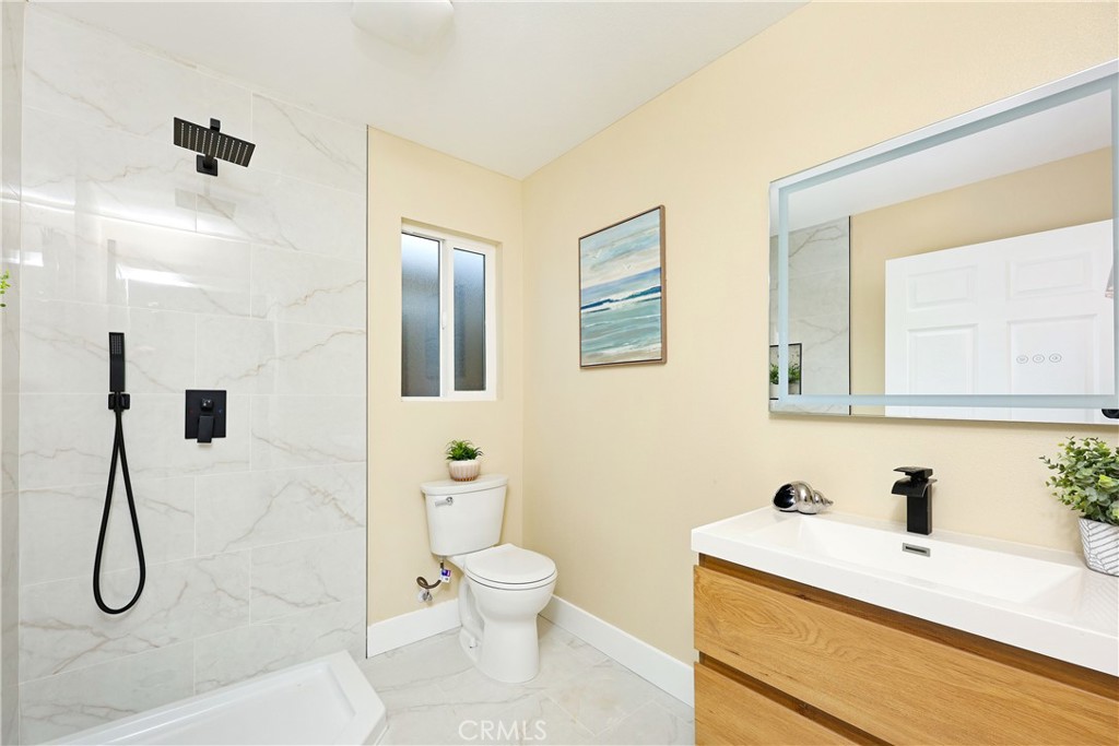 5571 Central Avenue Riverside, CA 92504 - Photo 16 of 21 a bathroom with a granite countertop sink a toilet and a mirror