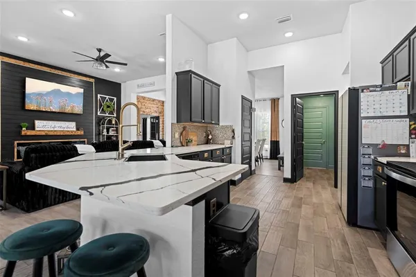 a kitchen with stainless steel appliances granite countertop a sink stove and refrigerator