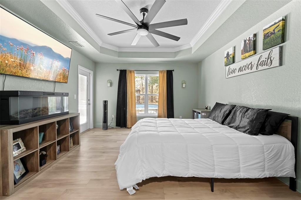 12034 Mandlin Road Weeki Wachee, FL 34614 - Photo 39 of 51 a bedroom with a large bed and a flat tv screen