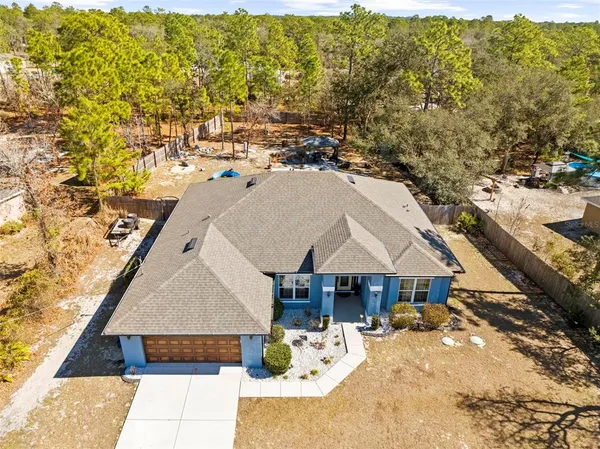 an aerial view of a house with swimming pool and sitting space