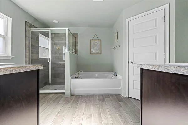 a bathroom with a tub sink and mirror