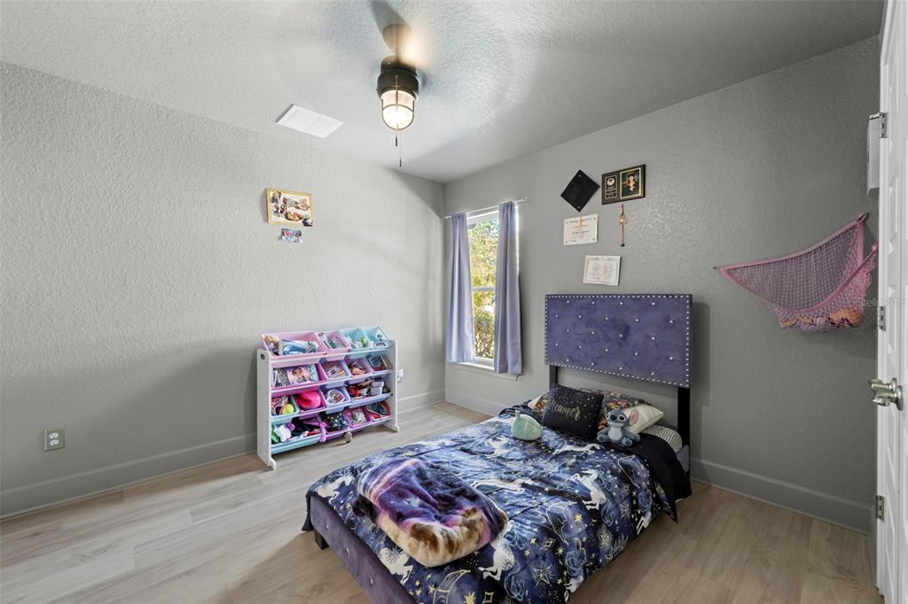 12034 Mandlin Road Weeki Wachee, FL 34614 - Photo 49 of 51 a bedroom with a bed and a chandelier