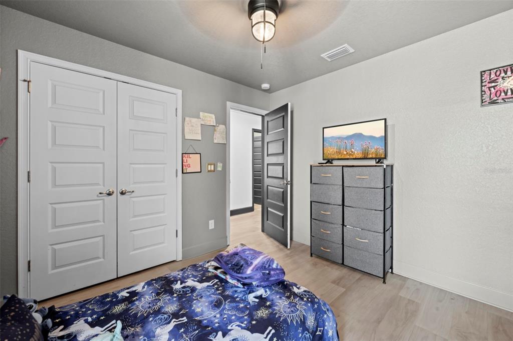 12034 Mandlin Road Weeki Wachee, FL 34614 - Photo 50 of 51 a bedroom with a bed and a chandelier